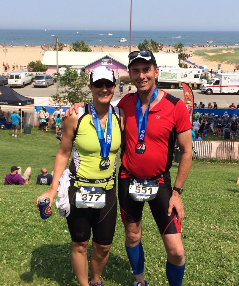 Lisa standing with another triathlon athlete after completing a race